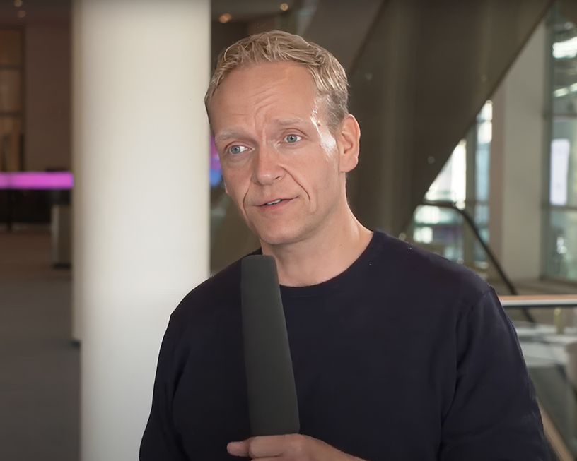 image of Frank Phlaen holding a microphone in a hallway at DMEXCO